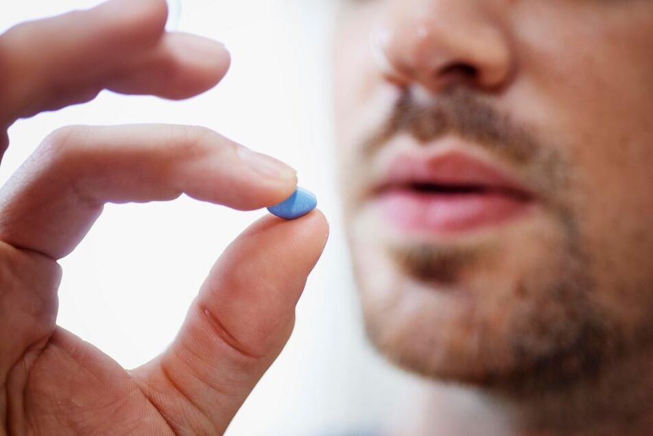 muž berie tabletku na stimuláciu potencie